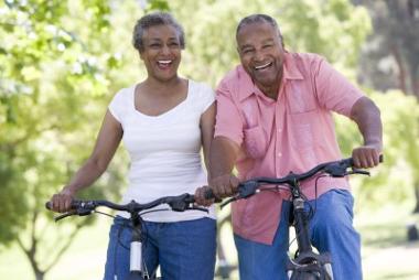 Senior couple smiling while on a cycle ride in the countryside