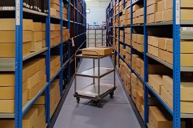 A photograph of a trolley next to shelving in a store room