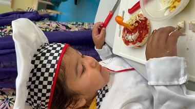 A child making a pizza at a mini chefs session at Central Link Children's Centre