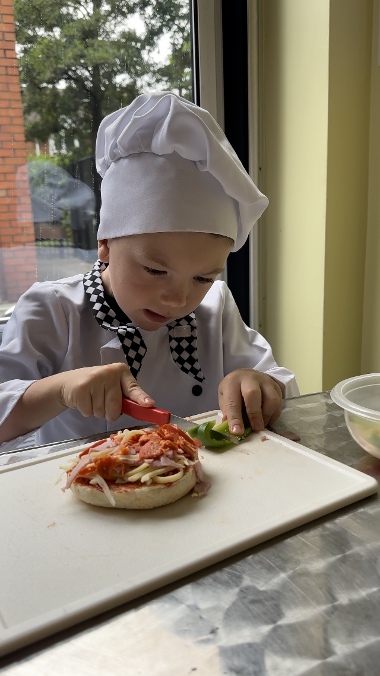 A child making a pizza at a mini chefs session at Central Link Children's Centre