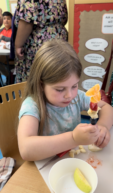 A child making a fruit kebab at a mini chefs session at Central Link Children's Centre